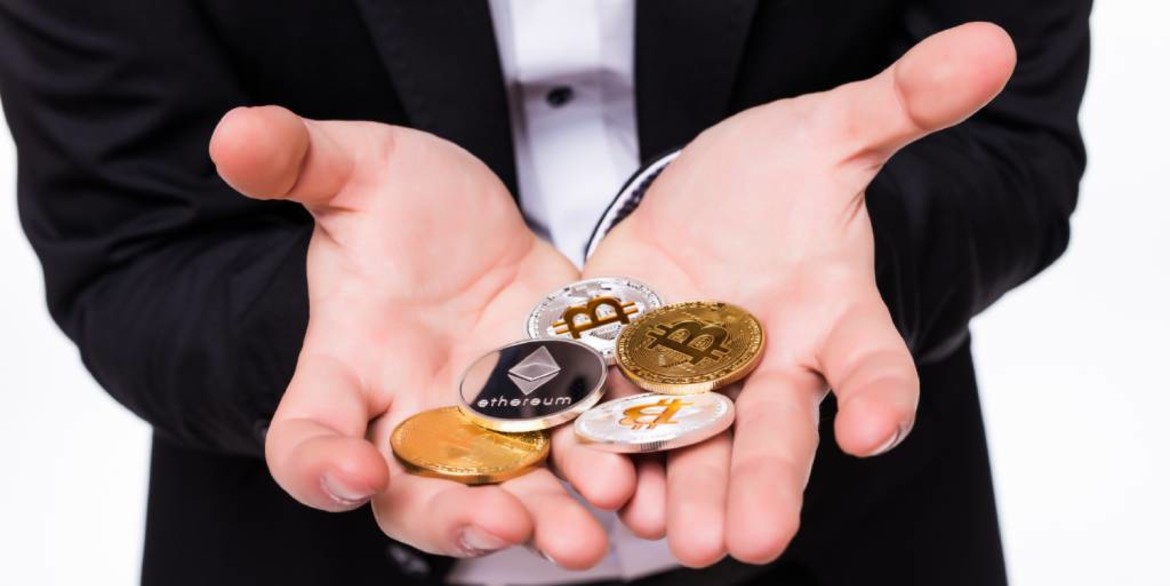 man-holds-different-crypto-coins-in-his-hands-on-white